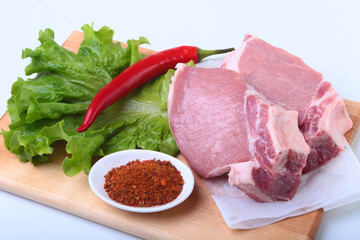 Raw pork chops with herbs and spices on cutting board. Ready for cooking.