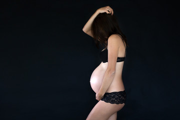 Portrait of Beautiful pregnant woman, isolated on black studio background