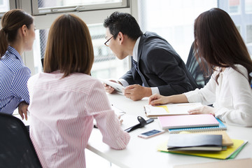 Four office workers are meeting in the meeting room
