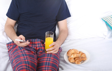 Man having breakfast and using phone.