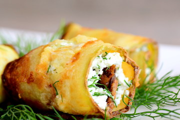 Vegetable rolls with cottage cheese filling. Fried zucchini rolls stuffed with cottage cheese and dill. Closeup