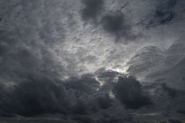 Obraz premium clouds with background,sunlight through very dark clouds background of dark storm clouds,black sky Background of dark clouds before a thunder.