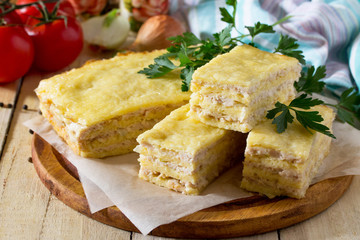 Meat casserole from minced meat and cheese on the kitchen table with fresh vegetables. The concept of a healthy diet.