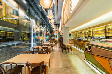 Interior of a modern urban restaurant with concrete floor in the night