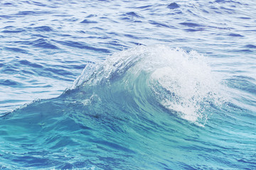 Turquoise blue wave on rippled sea water. Sea water closeup photo.