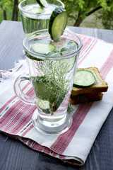 clean drinking water with cucumber and dill in a glass on a linen napkin