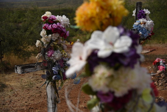 Kunstblumen an Grabkreuzen auf einem historischen Friedhof