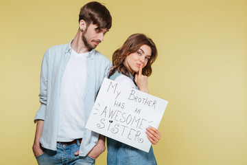 Happy brother and sister showing nameplate