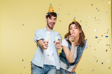 Happy brother and sister standing over yellow background