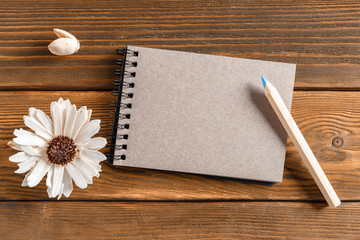 Naklejka na ściany i meble Blank notebook with flower on vintage wooden table