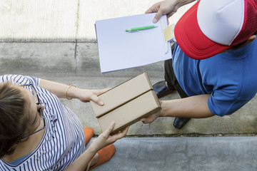 woman accepting on line shopping product from home delivery man ,top view scene