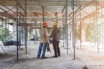 Engineer discussing with foreman about project in building construction site