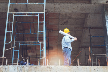 Engineer with blueprint in building construction site