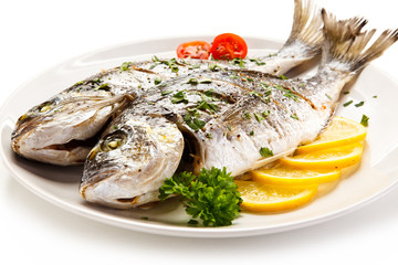 Fish dish - roast fish and vegetables on white background