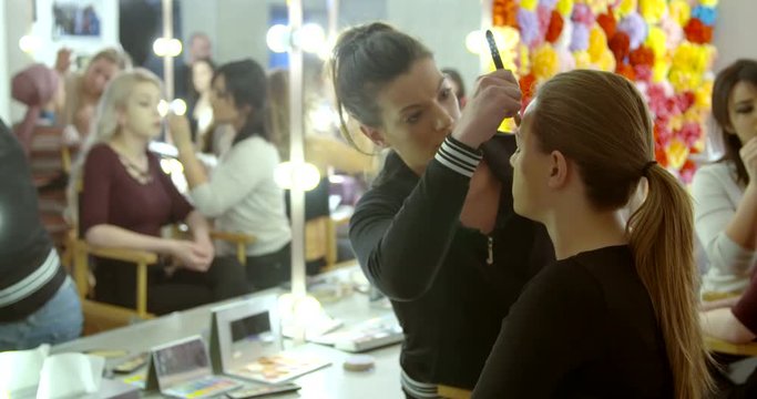 Makeup artist makes a girl beautiful makeup before  photo shooting