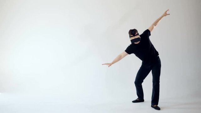 A man is wearing virtual reality headset making careful steps. White background. 4K.