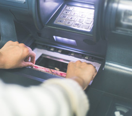 Woman using cash machine-ATM,close up view.