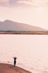 Woman standing at lake and mountain background with vintage filter