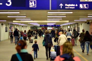 Menschenmenge mit Koffern läuft in zu Flughafen