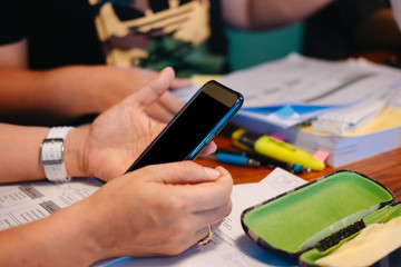 Fototapeta premium businessman using phone for checking something while consulting in meeting room. have business accessory and another document putting around him. this image for business,people and education concept