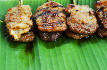 Close up of Delicious grilled pork mooping thai local street food on banana green leaf