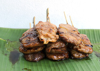 Delicious grilled pork mooping thai local street food on banana green leaf