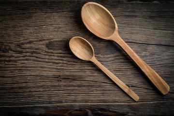 Wooden kitchen utensils on a wooden background. Copy space. Top view.