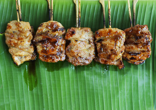 Grilled pork or mooping thai local street food on banana green leaf backgrounds above