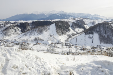 Idyllic winter landscape with mountains, sunny day; Bran, Romania