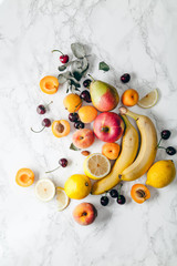 Summer fruits assorted on white marble background. Fresh raw food concept. Copy space