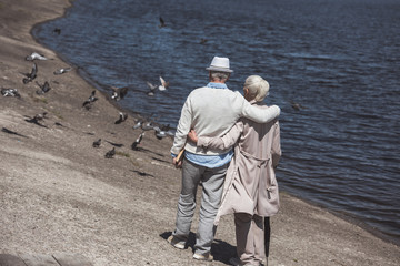 casual senior couple walking on river shore at daytime