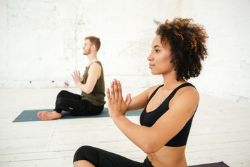 Obraz premium Side view of young african woman doing yoga