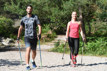 jeune couple pratiquant la marche nordique