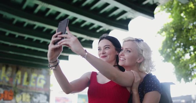 Female friends taking selfie in urban city