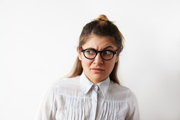 Portrait of skeptical Caucasian young entrepreneur female wearing white stripped shirt and...