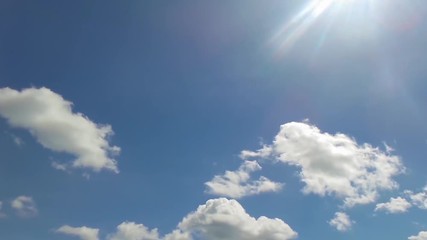 Time lapse of clouds moving in blue sky, plane flying and sunbeam