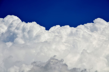 Naklejka na ściany i meble Blue sky with white and gray cumulus clouds. Closeup