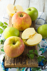 Red and green apples, mint leaves and a knife.