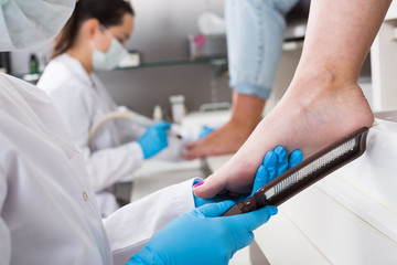 Nail pedicure technician performing procedure