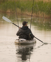 Fisherman in inflatable canoe.