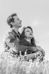 Affectionate young couple on the lawn in the park. Love story. Black and white.