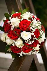 Bridal bouquet. The bride's . Beautiful of white flowers and greenery, decorated with silk ribbon, lies on vintage wooden chair
