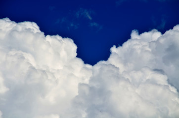 Blue sky with white and gray cumulus clouds. Closeup