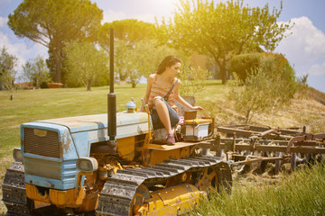 Young farmer woman on the vintage  tractor
