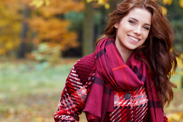 Portrait of beautiful brunette girl walking the park. Smiling. Warm sunny weather. Outdoors