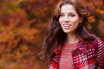 Portrait of beautiful brunette girl walking the park. Smiling. Warm sunny weather. Outdoors
