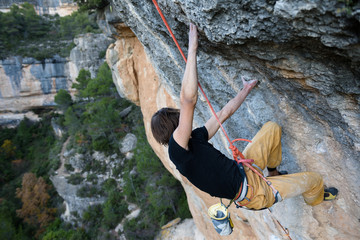 Rock climber ascending a challenging cliff. Extreme sport climbing. Freedom, risk, challenge, success. Sport and active