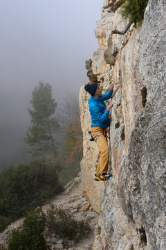 Rock climber ascending a challenging cliff. Extreme sport climbing. Freedom, risk, challenge, success. Sport and active.