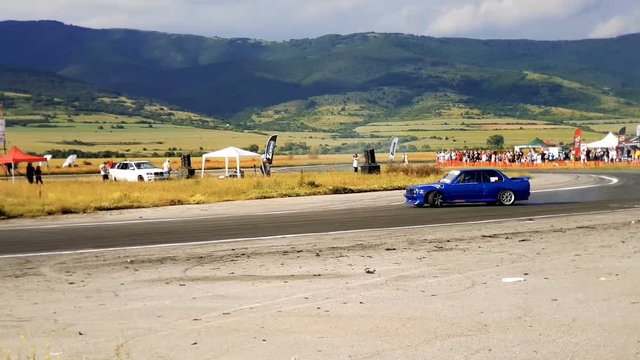 Blue racing car drifting the turn during a race