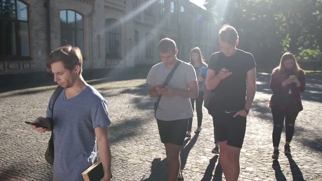 Students busy with smartphones on univesity campus
